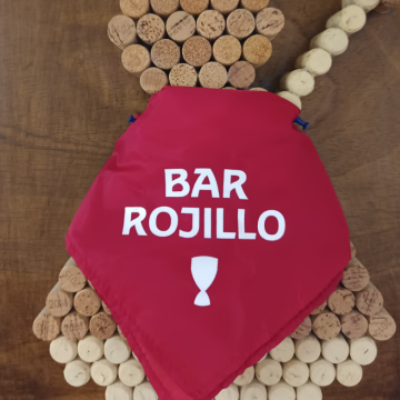 Imagen de Fermin hecha con corchos y a modo de capa el pañuelo rojo grabajo con el lema Bar Rojillo